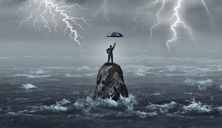 A picture of an agent stood on a rock out at sea in a storm holding an umbrella