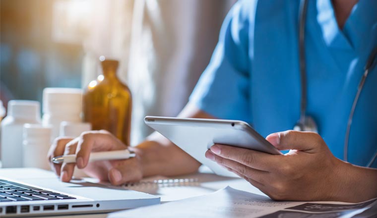 A picture of medical staff using a laptop and tablet