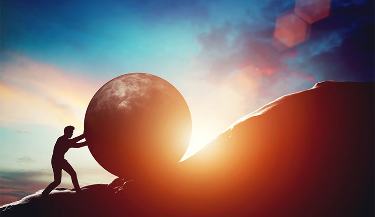 A picture of someone pushing a concrete ball up a hill