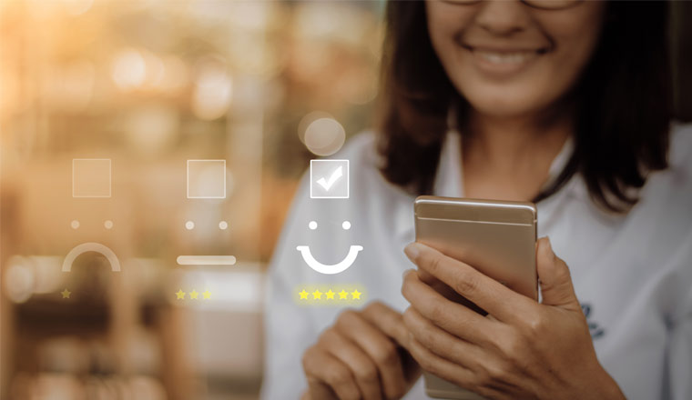 A picture of a customer smiling and looking at her smart phone