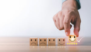 A photo of a smiling wooden block being picked up