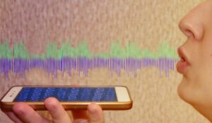 A picture of a lady speaking into a mobile phone with sound waves