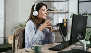 A picture of a smiling agent wearing a headset and speaking to a customer