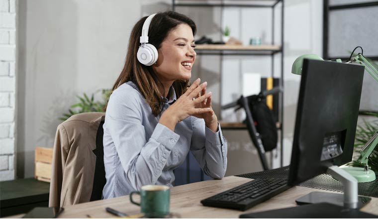 A picture of a smiling agent wearing a headset and speaking to a customer