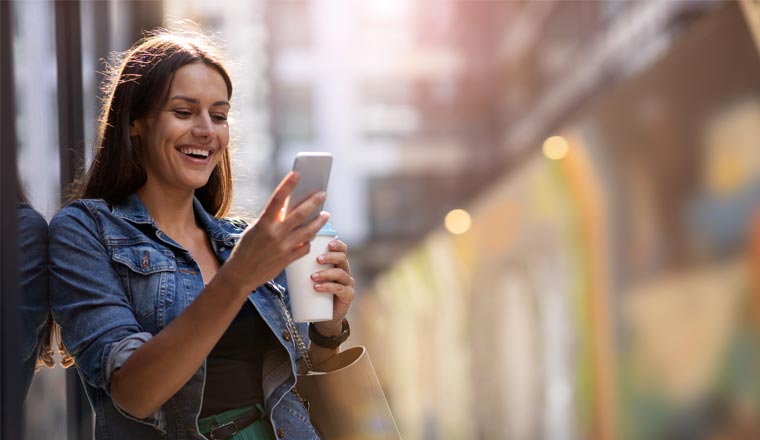 A picture of a customer smiling at her phone