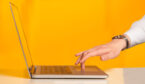 A picture of a laptop and hand on keyboard