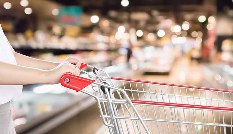 Hand pushing shopping trolley