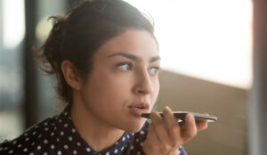 A picture of a woman using voice recognition on her mobile phone