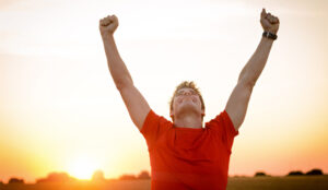 A man celebrating a win with his hands in the air