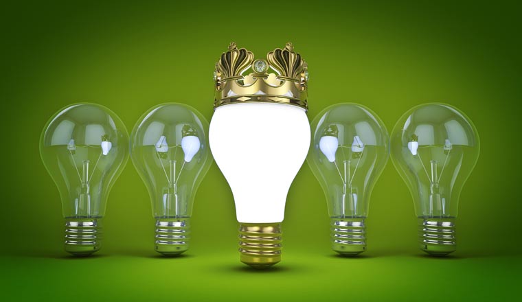 A picture of an illuminated lightbulb with a golden crown in front of four lightbulbs