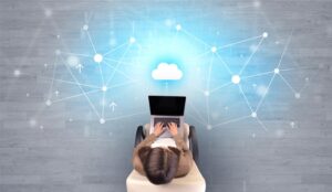 A picture of a woman on a laptop with cloud data