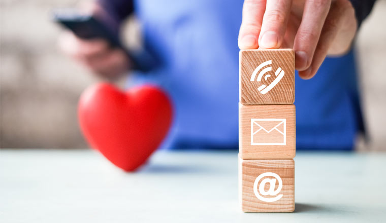 A picture of three blocks with phone, email and website icons in front of a heart