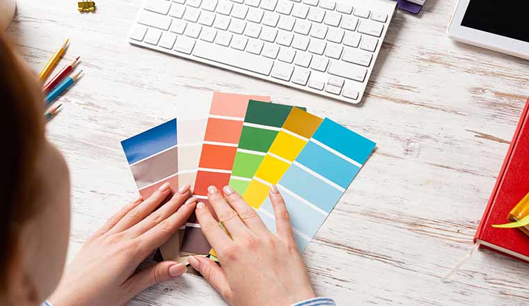 A picture of someone looking at colour swatches on a desk