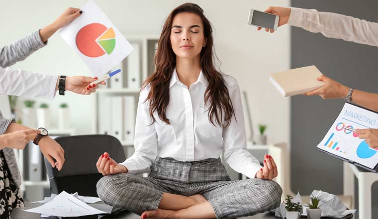 A picture of an agent sat on her desk meditating