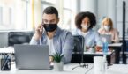 A picture of office workers wearing masks and socially distanced