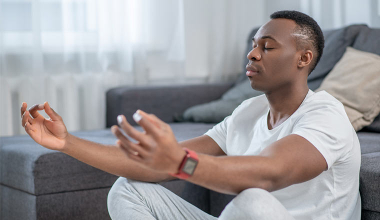 A picture of a person in white clothes meditating and looking peaceful