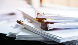 A stack of paper documents with clip papers on table