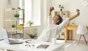 A person sitting at an office desk stretching