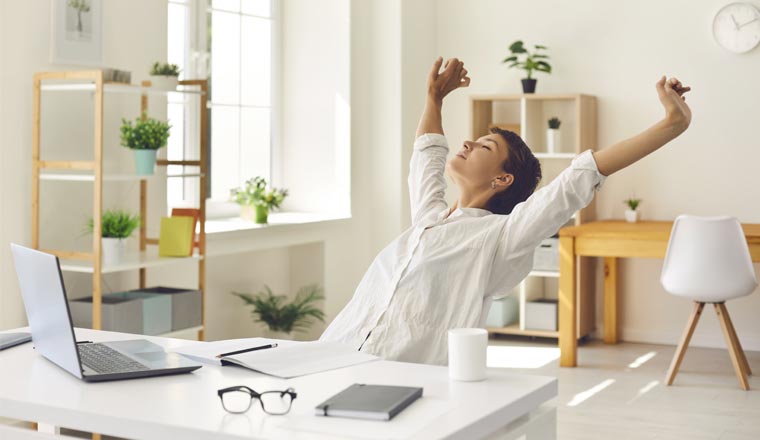 A person sitting at an office desk stretching