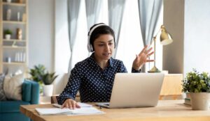 A person wearing headphones on a laptop