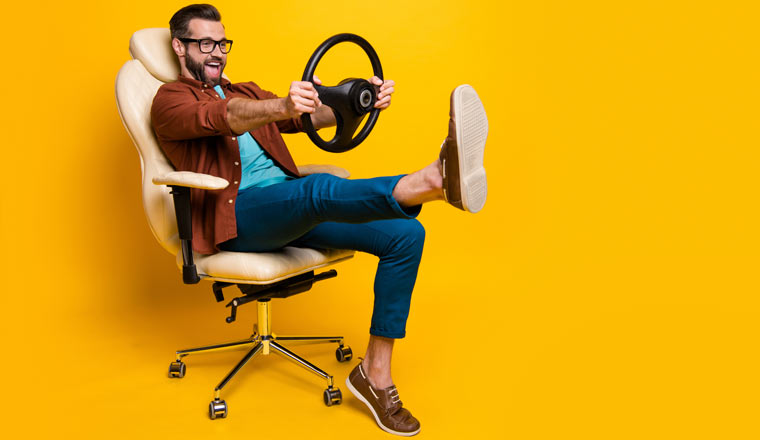 Happy person in a chair holding a steering wheel