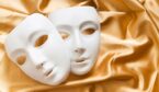 Theatre concept with the white plastic masks on gold fabric
