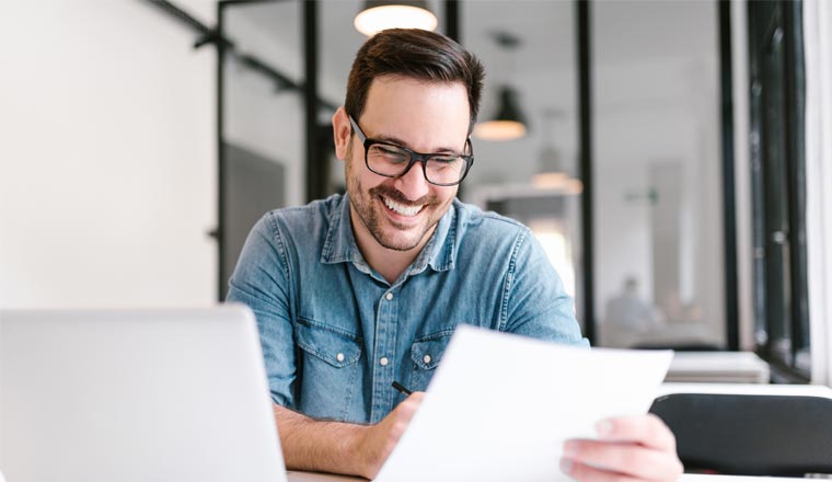 A person smiling looking at paperwork