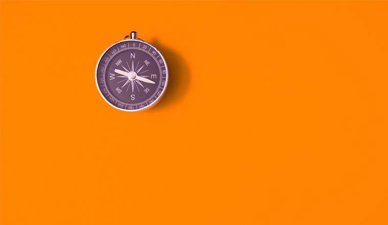 Black compass on orange background