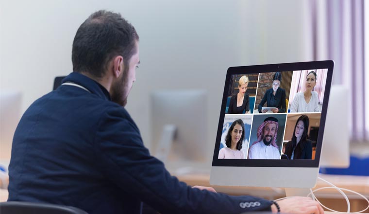 A person sat on a video call with six other people