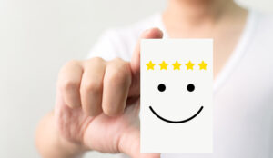 Person holding card with smiley face and five stars