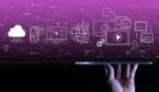 Hand using a digital tablet computer on dark violet background