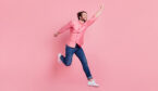 Person jumping having fun success isolated over pink pastel color background