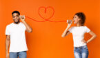 Two people with a can phone on an orange background