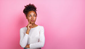 A person in a thinking pose on a pink background