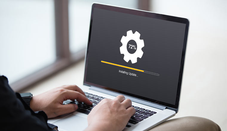 Person Installing update process with gearbox percentage progress and loading bar on laptop