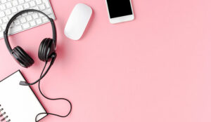 Helpdesk headset and computer accessories on pink background