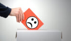 Person putting an unhappy rating in a feedback box