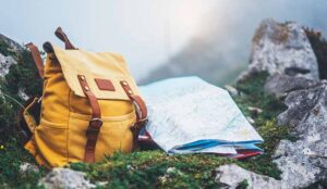 A yellow backpack and map on mountain background