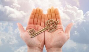 Hands holding a key with clouds in the background