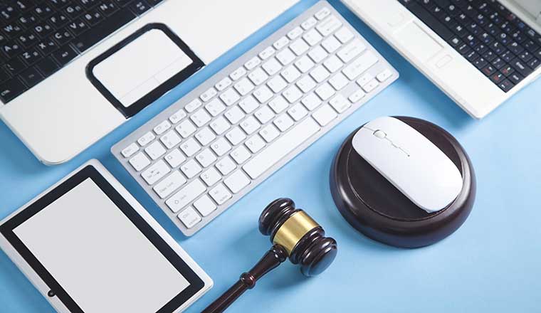Judge gavel with a computer mouse, keyboard, tablet, laptop.