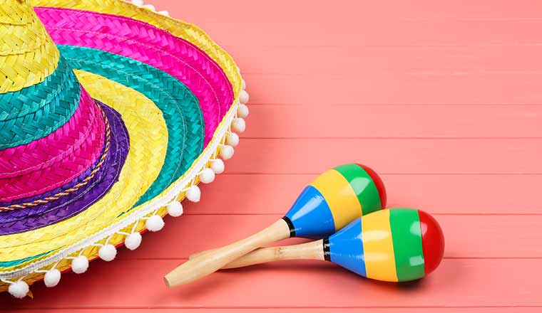 Mexican hat and maracas on wooden table