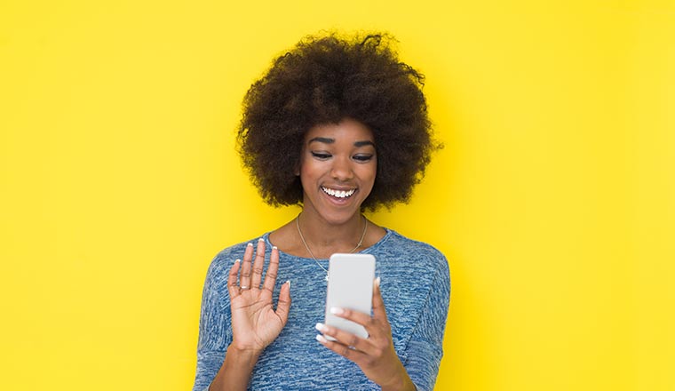 Person on phone isolated on yellow background