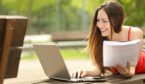 Person with notepad and laptop learning outside