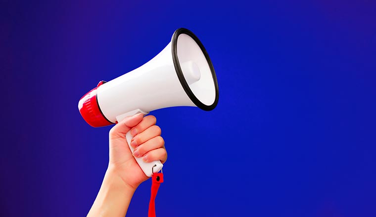 Image of hand with megaphone on empty blue background