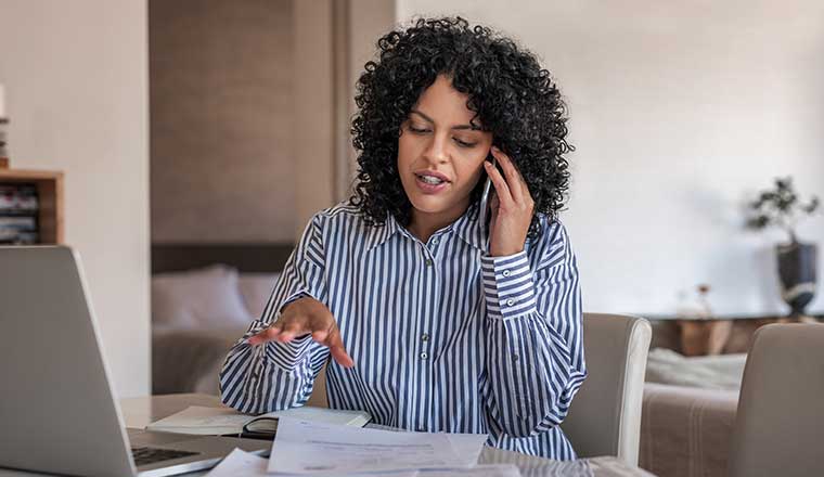 Person talking on phone going through paperwork