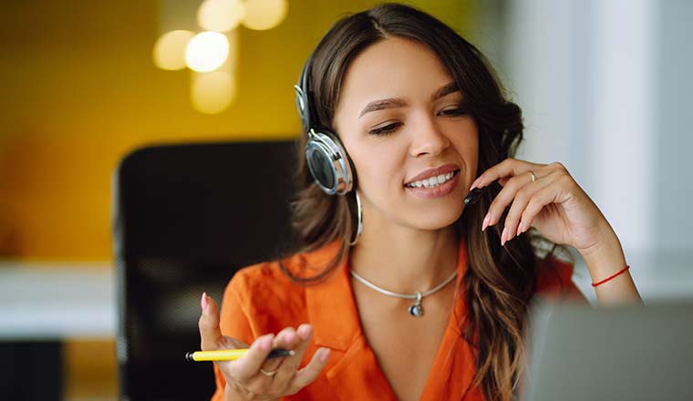 Happy agent with headsets working in a call centre.