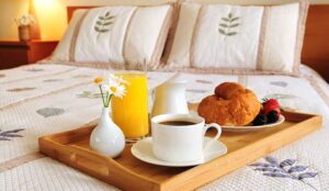 Breakfast on a bed in a hotel room