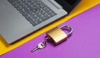 Laptop and lock on purple yellow paper background