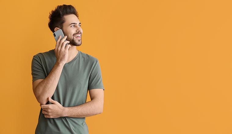 Person talking on mobile phone on color background