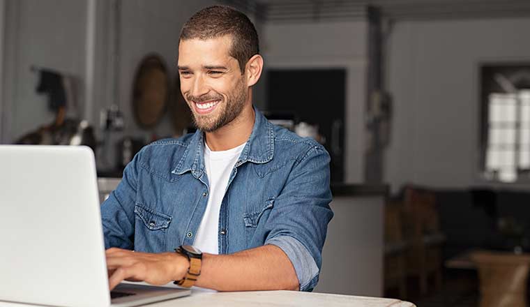 A happy person working on a laptop